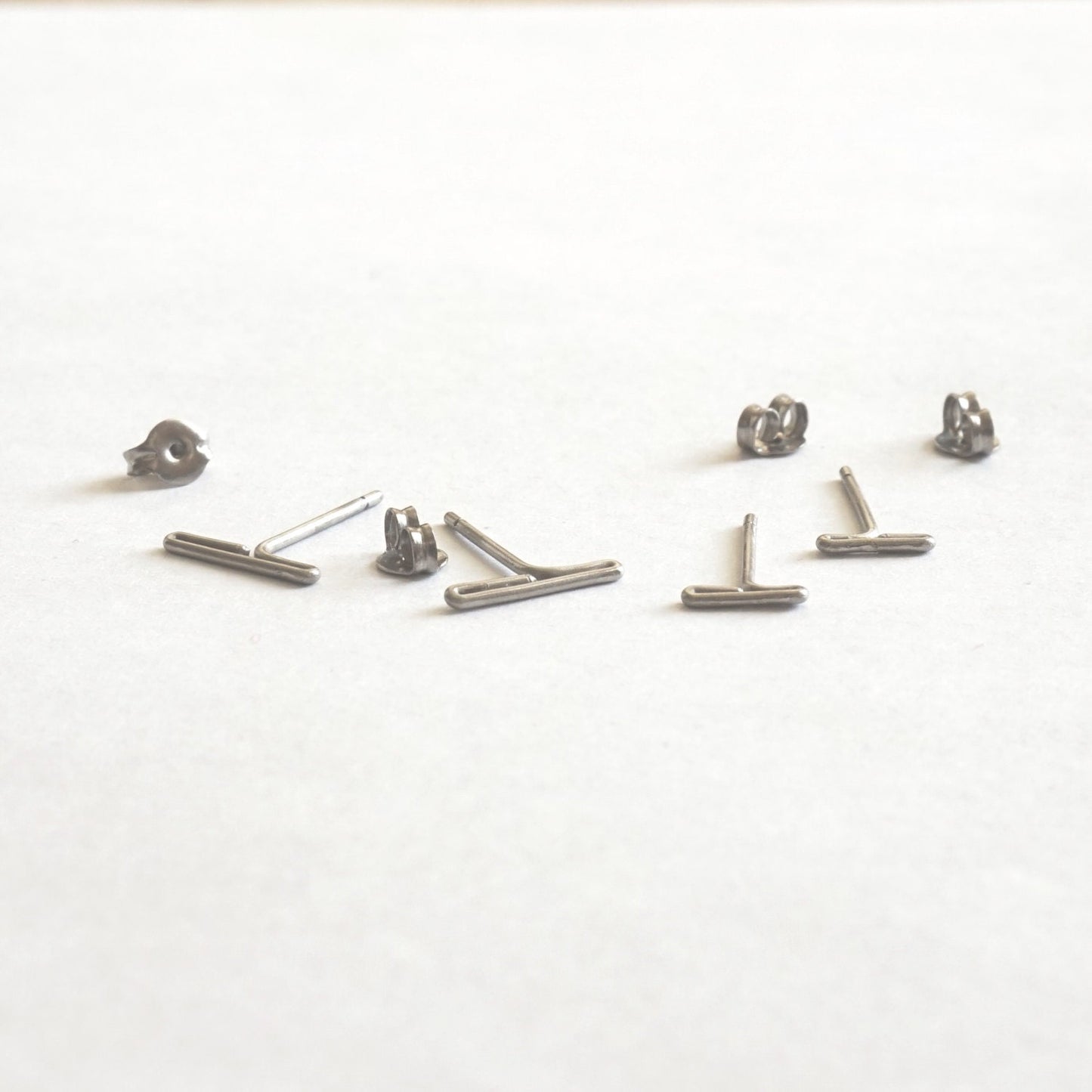 Two sets of hypoallergenic titanium earrings: Minimalistic design, available in 7mm and 11mm sizes. Perfect for everyday wear and sensitive ears.